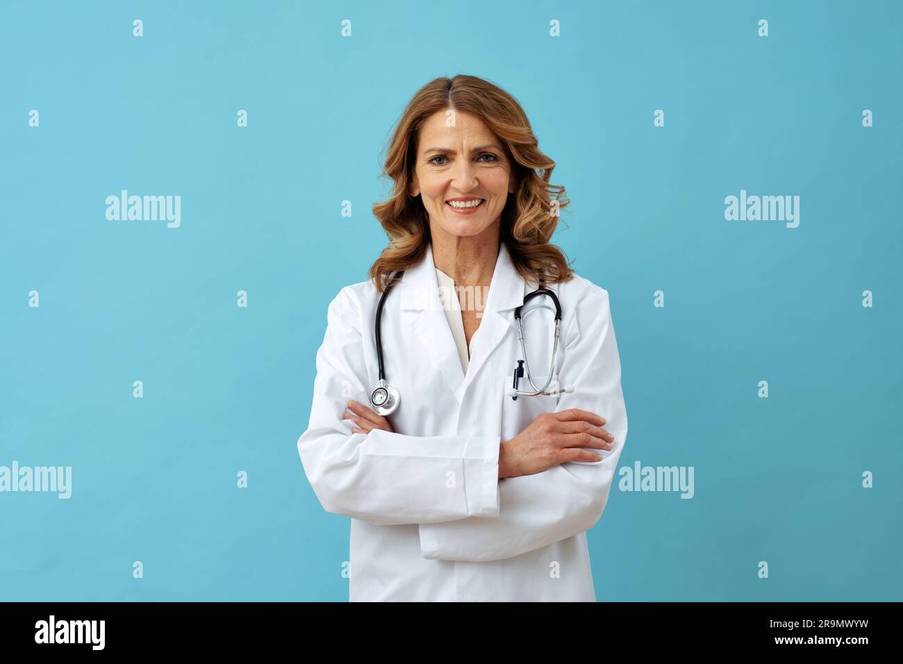 femme moyenne médecin adulte avec les bras croisés souriant regardant la caméra Banque D'Images