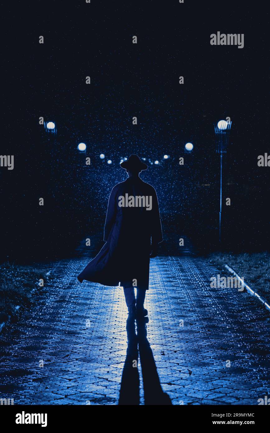 homme agent détective dans un chapeau et imperméable la nuit dans une ville pluvieuse dans le style de film noir Banque D'Images