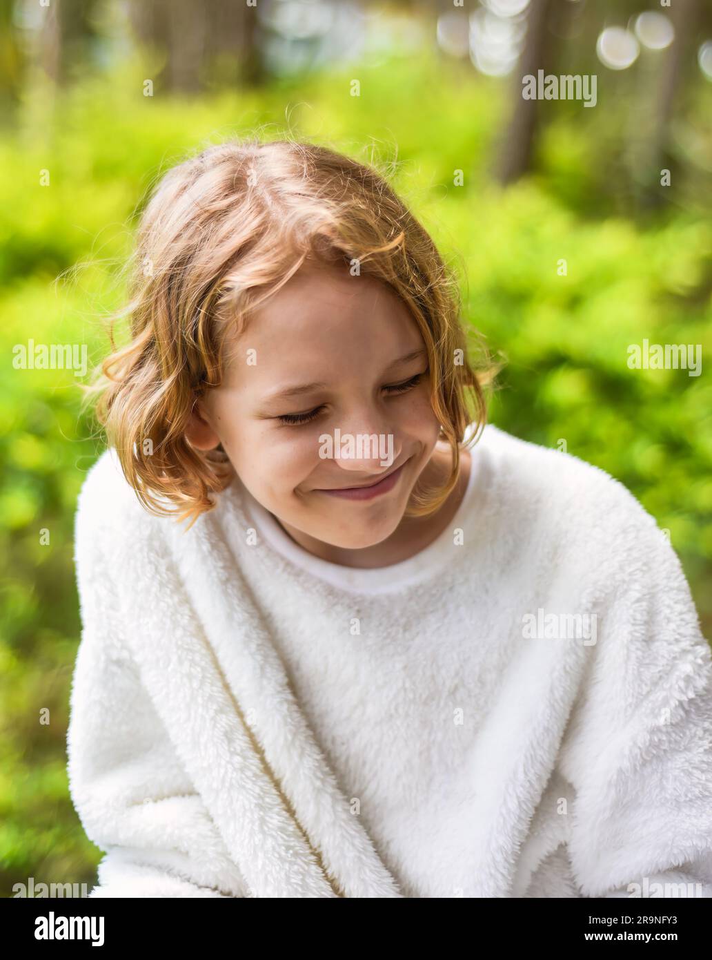 Portrait de timide 10 ans blonde maurie fille sourire et se cacher Banque D'Images