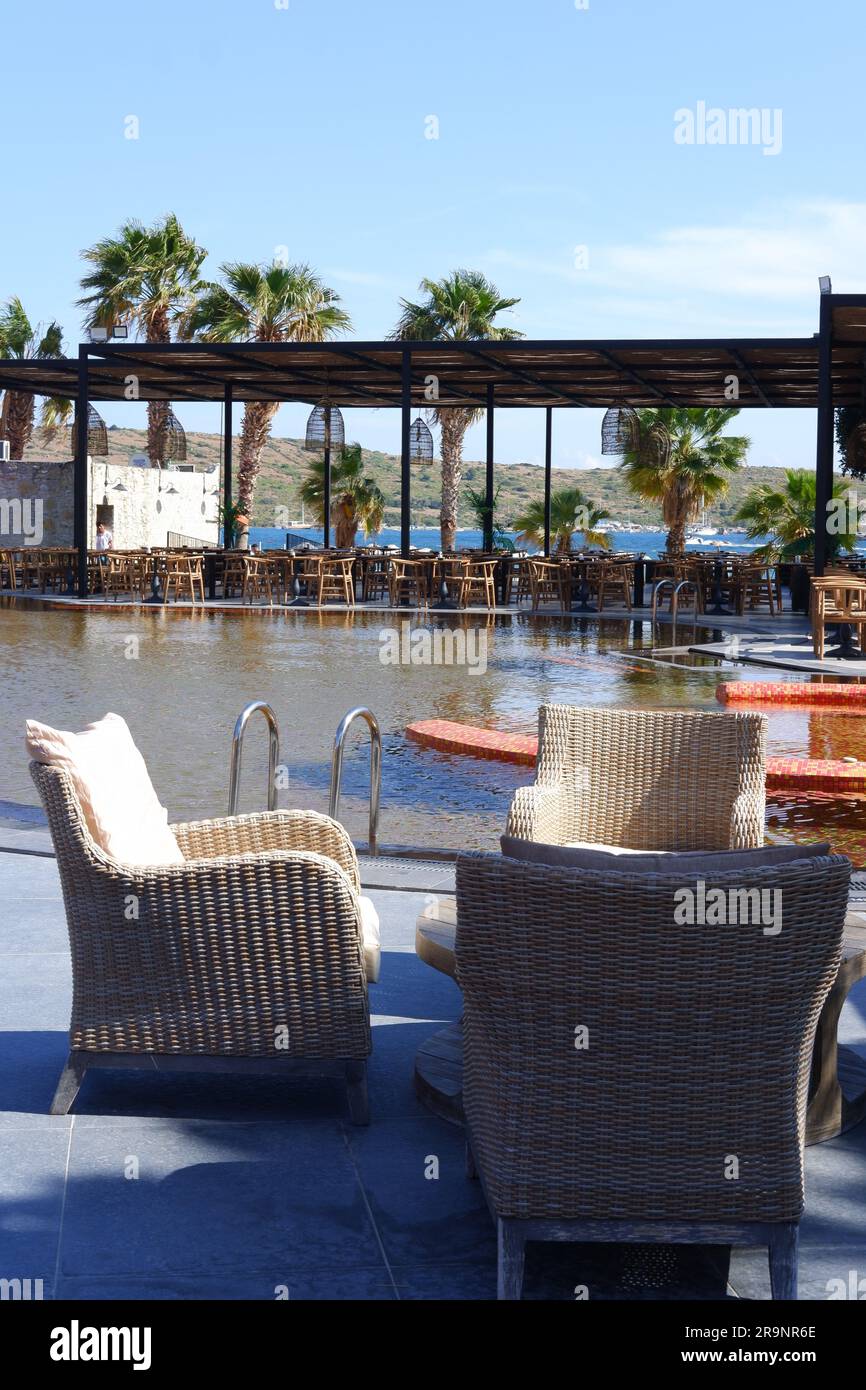 Tables et chaises en bois au bord de la piscine dans un hôtel Banque D'Images