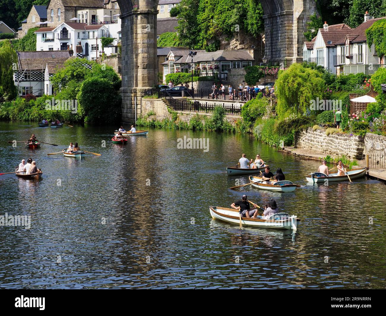 Les gens qui ravirent sur la rivière Nidd sous le viaduc ferroviaire lors d'une journée ensoleillée à Knaresborough North Yorkshire England Banque D'Images