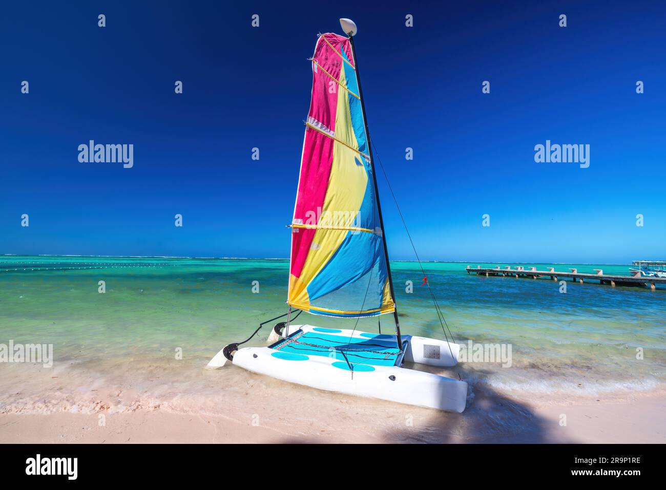 Catamaran couleur, planche à voile, kayak et paravoile en été, activités aquatiques sur la plage de l'île tropicale et sur la rive de la mer des caraïbes Banque D'Images