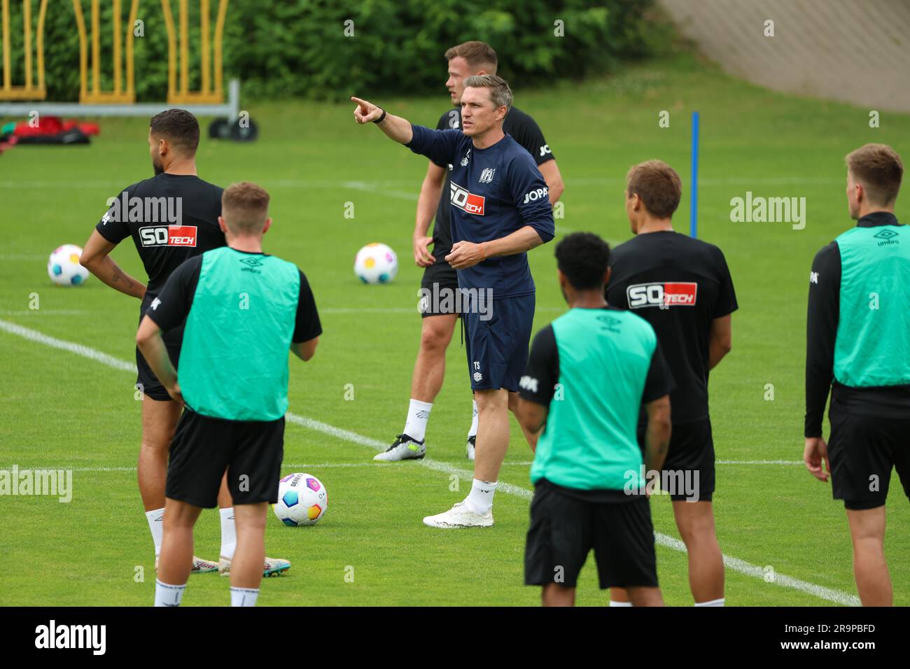 28 juin 2023, Basse-Saxe, Osnabrück: Football: Ligue 2nd, VfL Osnabrück, lancement de l'entraînement au terrain d'entraînement d'Illoshöhe. L'entraîneur d'Osnabrück Tobias Schweinsteiger (au centre) donne des instructions à ses joueurs. Photo: Friso Gentsch/dpa Banque D'Images