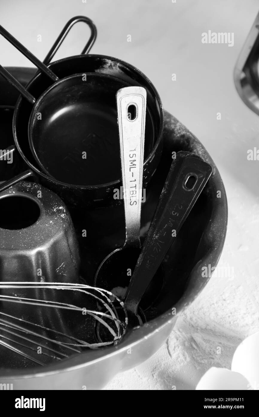 Un bol en céramique rempli d'ustensiles de cuisine sur une table. Banque D'Images