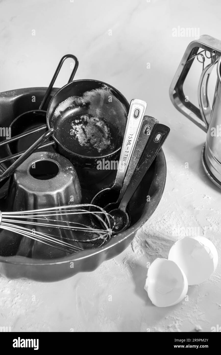 Un bol noir rempli d'ustensiles de cuisine sur une table. Banque D'Images