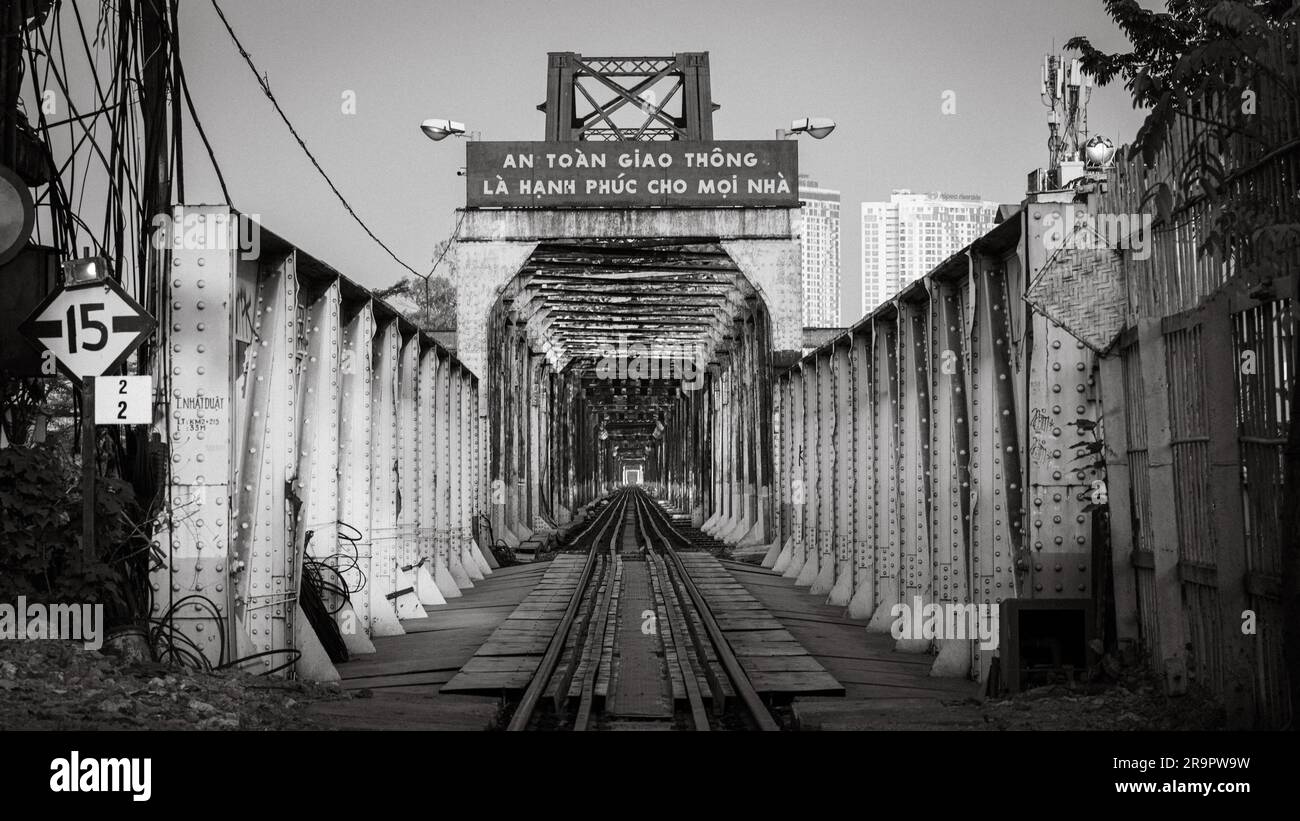 Une vue le long des voies ferrées à travers le long pont Rusty de Bien à Hanoi, Vietnam. Le panneau indique: La sécurité de la circulation est le bonheur de chaque maison Banque D'Images