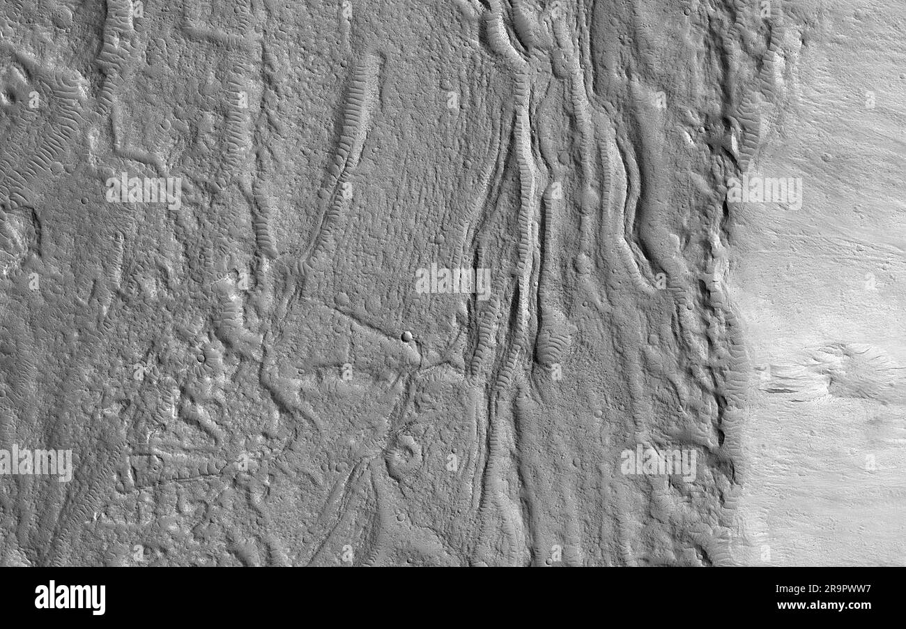 Glacial (glace) ou débit de lave. Le cadre géologique et la latitude suggèrent ici qu'il s'agit d'un écoulement glaciaire (riche en glace), mais la surface est divisée en plaques comme beaucoup de coulées de lave sur Mars. Une image a été ciblée ici pour obtenir un meilleur look. À la résolution de l'échelle du mètre de HiRISE, nous voyons une surface hummockée avec des rochers et des cratères, ainsi que quelques formes de terrain soufflées par le vent qui semble compatible avec l'hypothèse de la glace ou de la lave. Il s'agit d'un résultat courant, l'obtention d'une image à haute résolution ne fournit pas nécessairement plus d'informations sur les processus à grande échelle, mais plutôt des informations sur la façon dont la surface Banque D'Images