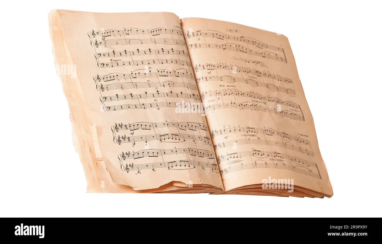 Ordinateur portable. Livre ouvert avec livre de notes musicales. Vieux manuel de musique isolé. Gros plan de partitions isolées sur fond blanc. Panneau classique. Remarque avec mise au point sélective. Banque D'Images