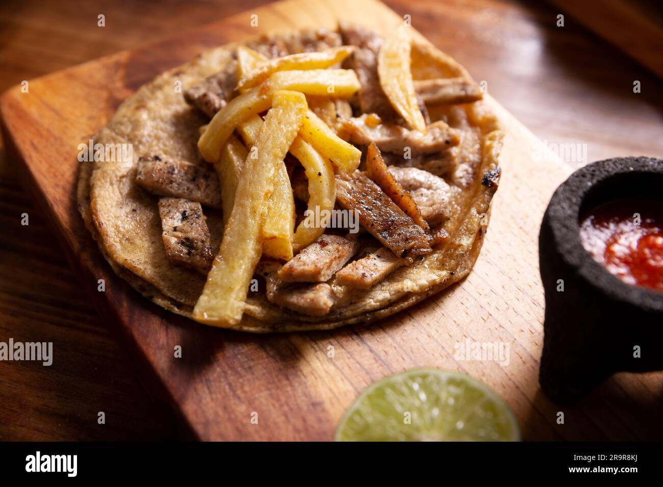 Tacos au bœuf et frites. Taco très populaire au Mexique appelé Taco de Bistec ou Carne Asada, rôti de bœuf fait maison servi sur une tortilla de maïs. Moi Banque D'Images