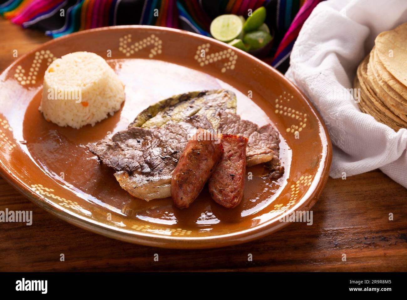 Viande rôtie avec cactus nopal rôtis et saucisse de porc appelée chorizo, accompagnée de riz blanc servi dans une assiette typiquement mexicaine en argile. Banque D'Images