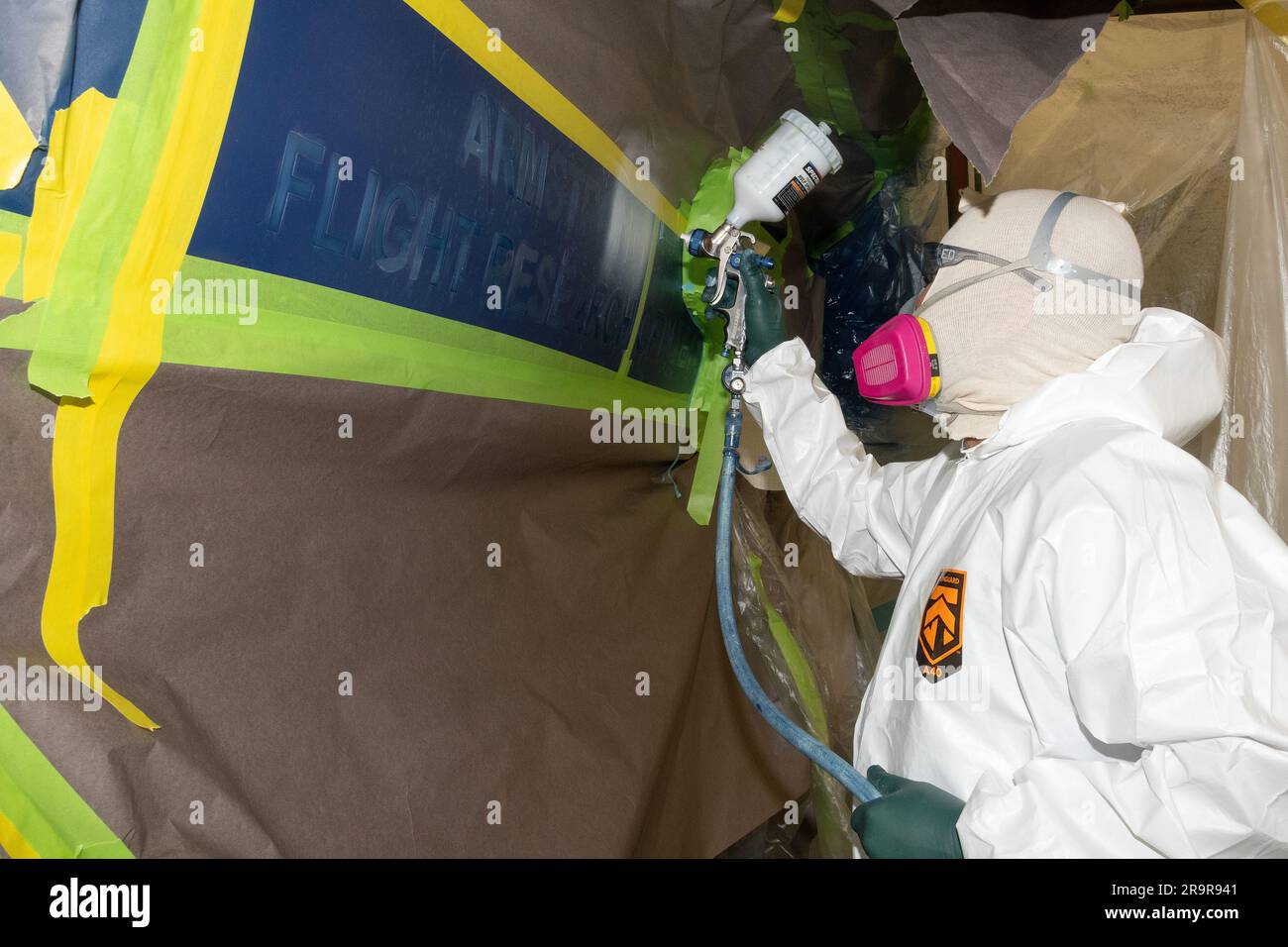 Eric Miranda travaille à l'installation de contrôle de la corrosion de l'US Air Force sur la base aérienne d'Edwards, appliquant de la peinture au pochoir sur NASA 862, un avion F/A-18D basé au centre de recherche en vol Armstrong de la NASA en Californie. L'installation est connue sous le nom de Paint Barn. Banque D'Images