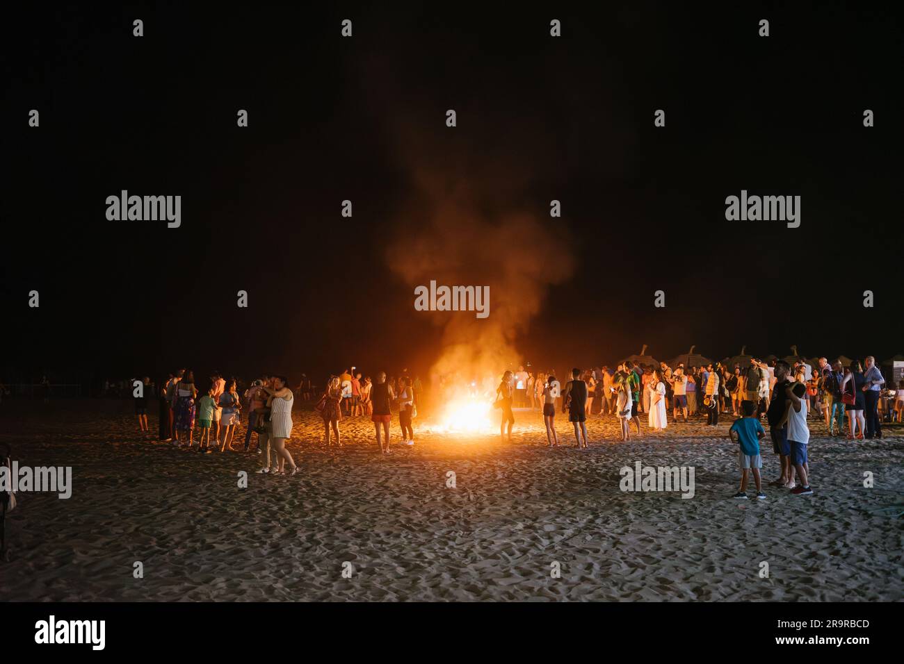 Malaga, Espagne - juin, 24, 2023: Les gens autour du feu de joie sur la plage pour le festival populaire de la journée de San Juan au solstice d'été. Banque D'Images