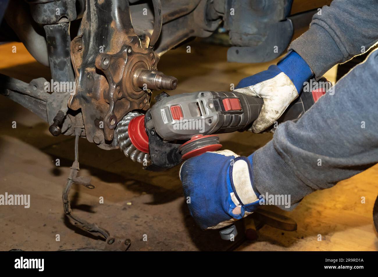 Le mécanicien de voiture nettoie, fait dérailler et entretient le roulement de moyeu de roue. Gants de protection. En fonctionnement. Banque D'Images