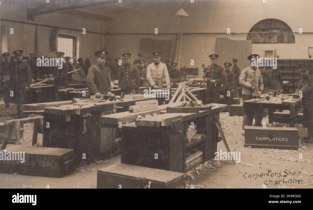 Magasin de menuisiers, Chatham: Photographie de la première Guerre mondiale d'hommes et de garçons en uniforme militaire autour des bancs de travail du bois. Les outils de menuiserie se trouvent sur les bancs et dans les troncs de l'atelier Banque D'Images