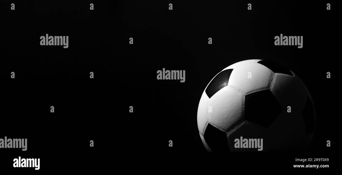 Ballon de football sur fond noir. Affiche sur le thème du sport horizontal, cartes de vœux, en-têtes, site Web et application Banque D'Images