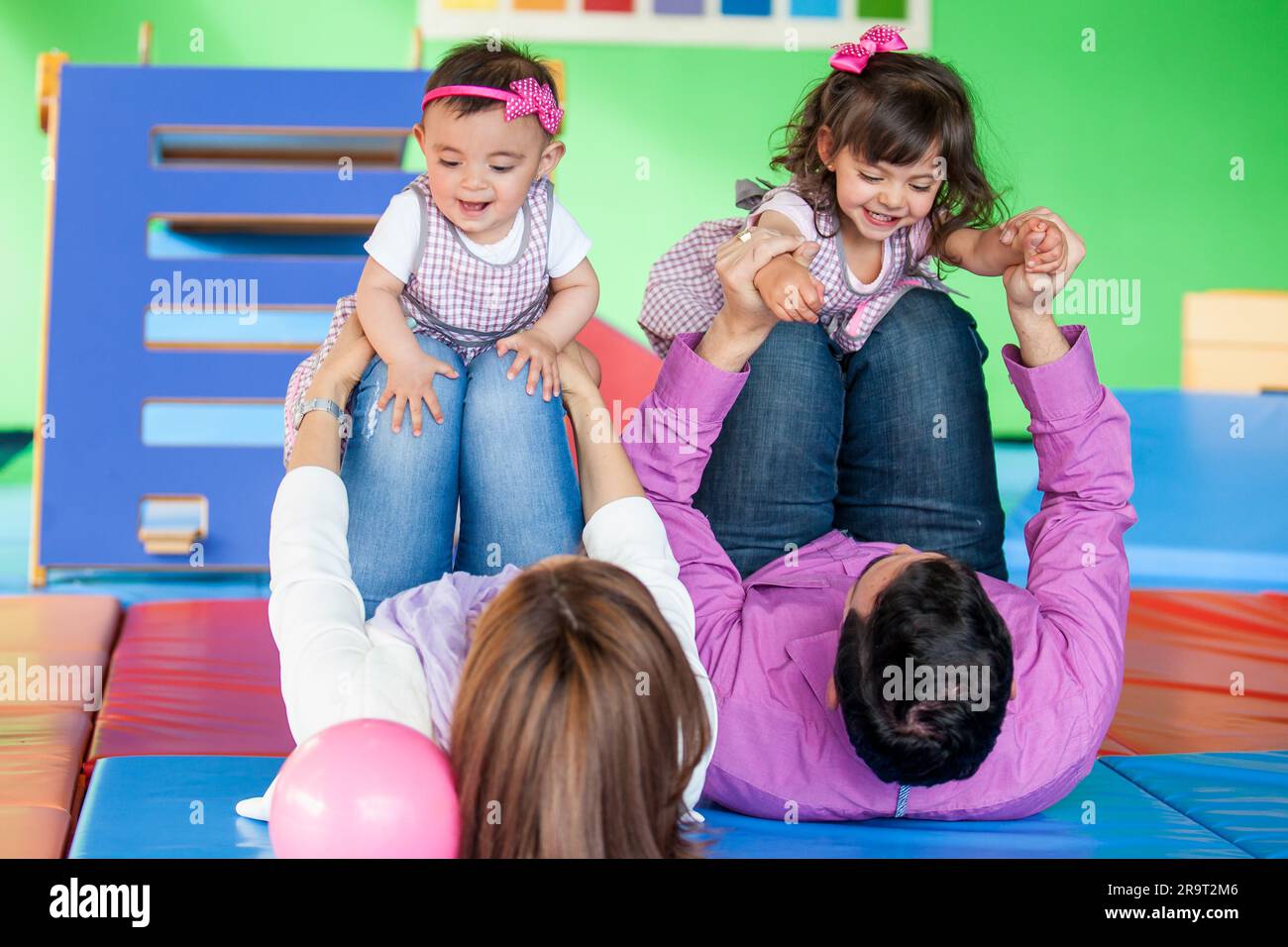 Jeunes parents jouant avec leurs filles. Stimulation précoce pour les tout-petits et les enfants concept. Banque D'Images