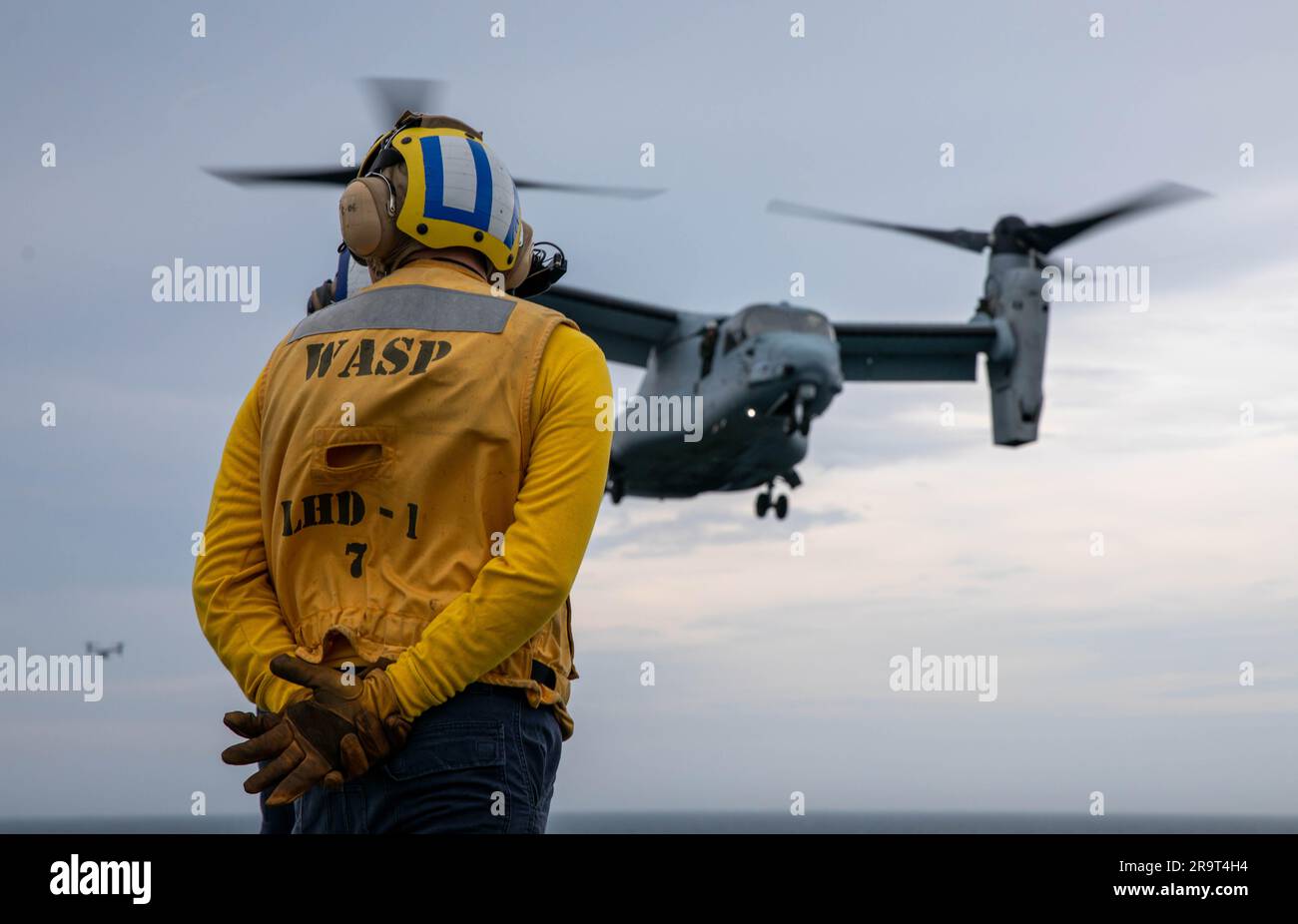 230623-N-XO158-1099 OCÉAN ATLANTIQUE (23 juin 2023) Aviation Boatswain’s Mate (Handling) Airman Mason Woods observe pendant son instruction comme un MV-22B Osprey, affecté aux « Chevaliers bleus » de l’escadron marin à Tiltrotor moyen (VMM) 365, atterrit sur le pont de vol du navire d’assaut amphibie USS Wasp (LHD 1) pendant les opérations de vol, 23 juin 2023. Wasp procède actuellement à des tests et à des évaluations de la phase de base. (É.-U. Photo de la marine par le spécialiste des communications de masse 2nd classe Sydney Milligan) Banque D'Images