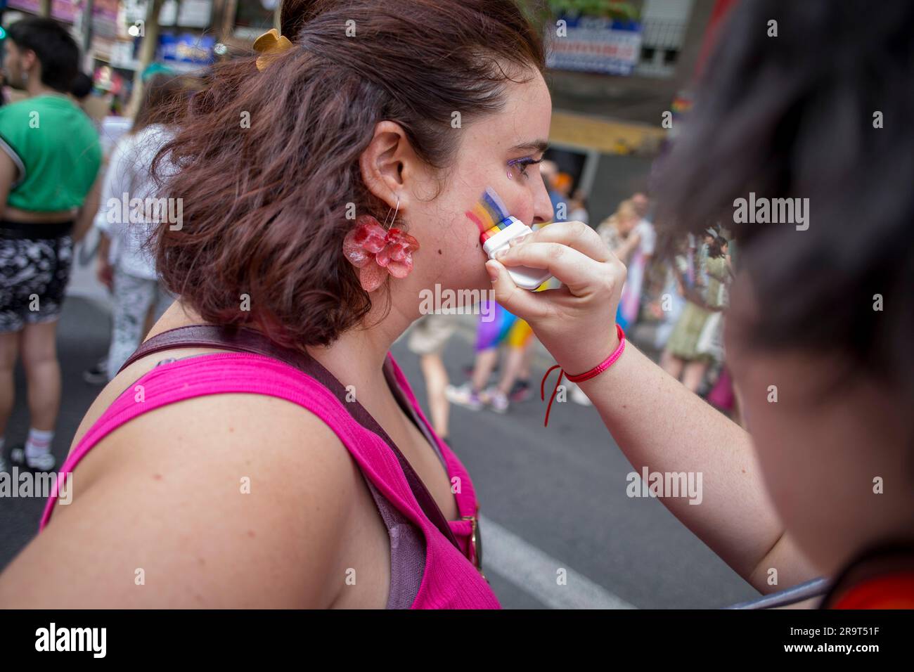 Madrid, Espagne. 28th juin 2023. Une femme peint sa joue avec le drapeau de la fierté lors de la Marche critique de la fierté à travers les rues de Madrid. Différents groupes qui composent la plate-forme critique de la fierté de Madrid ont organisé une manifestation alternative contre les événements officiels de la fierté mondiale et cherche à justifier les droits du collectif LGTBIQ. Crédit : SOPA Images Limited/Alamy Live News Banque D'Images