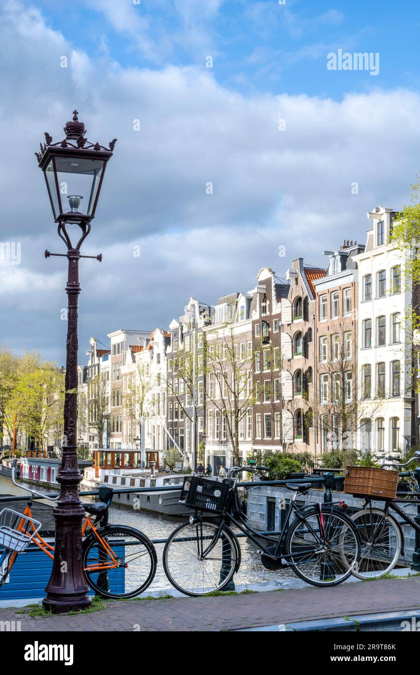Pont au-dessus d'un canal avec maisons à pignon dans le backgound et vélos garés sur le pont à Amsterdam Banque D'Images