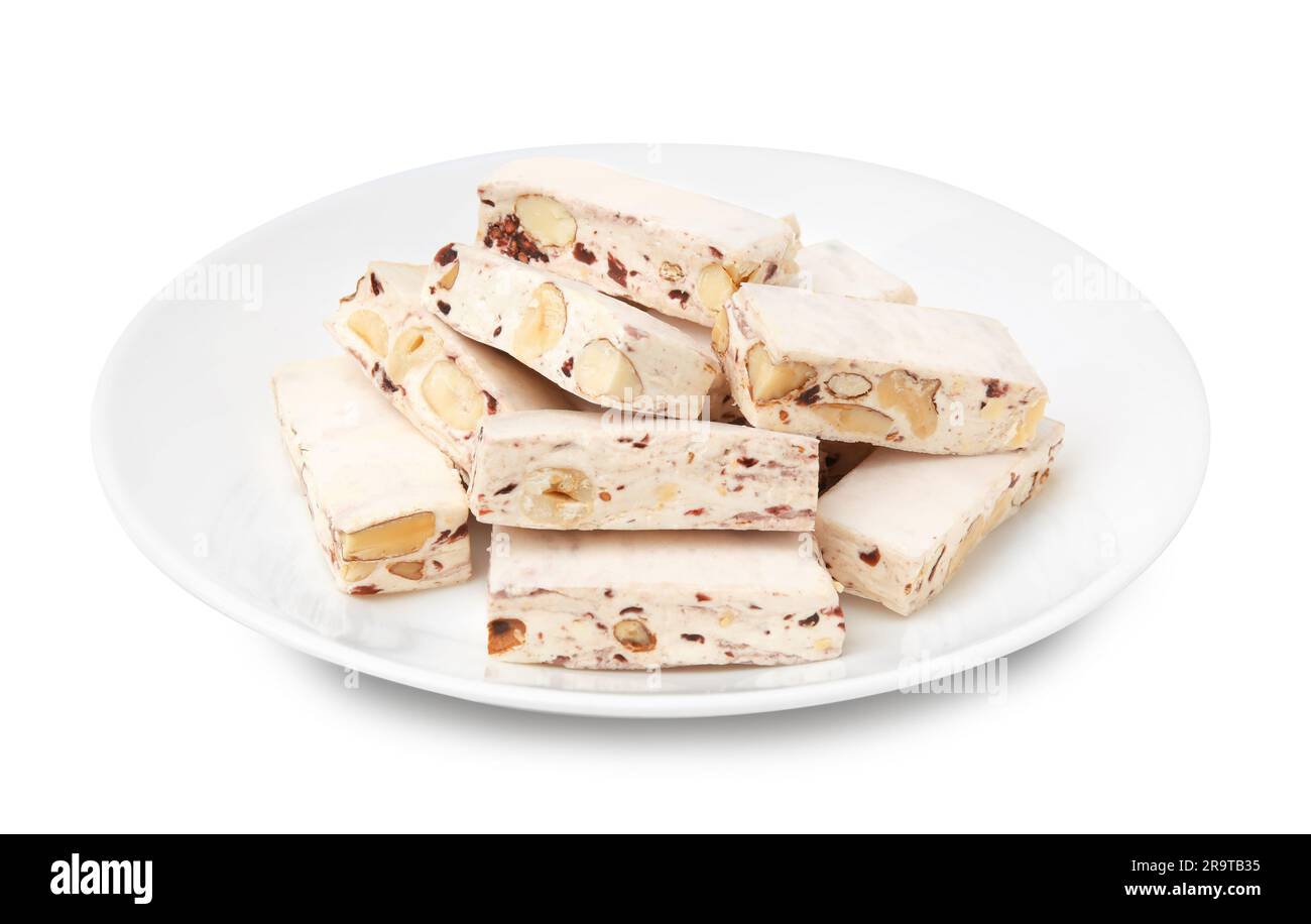 Assiette avec morceaux de délicieux nougat isolé sur blanc Banque D'Images