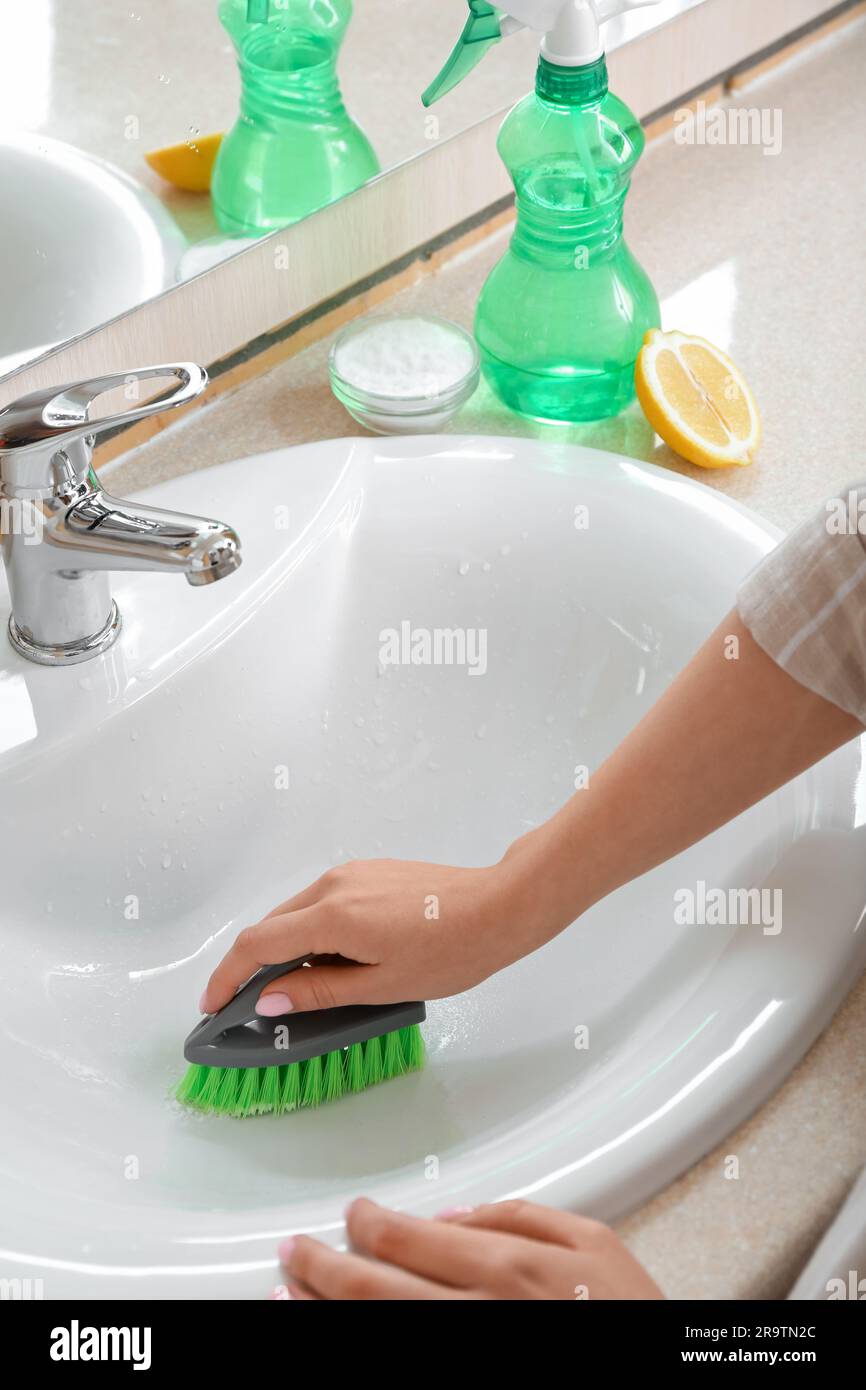 Femme nettoyant évier en céramique blanc avec brosse et bicarbonate de soude,  gros plan Photo Stock - Alamy