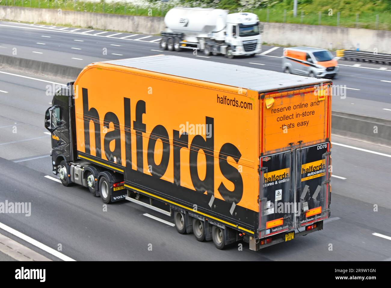 Halfords commerce de détail noir Volvo prime Mover hgv camion remorquage corps rigide articulé semi-remorque orange marque panneau publicitaire UK Highway Road Banque D'Images