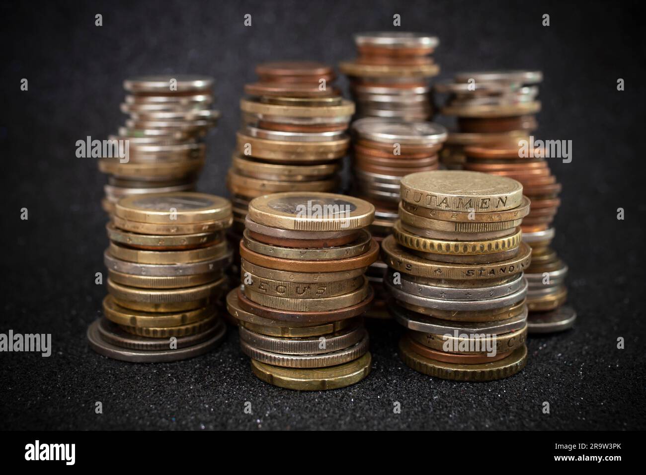 piles de pièces de monnaie européennes, sur fond noir pailleté, gros plan flou Banque D'Images