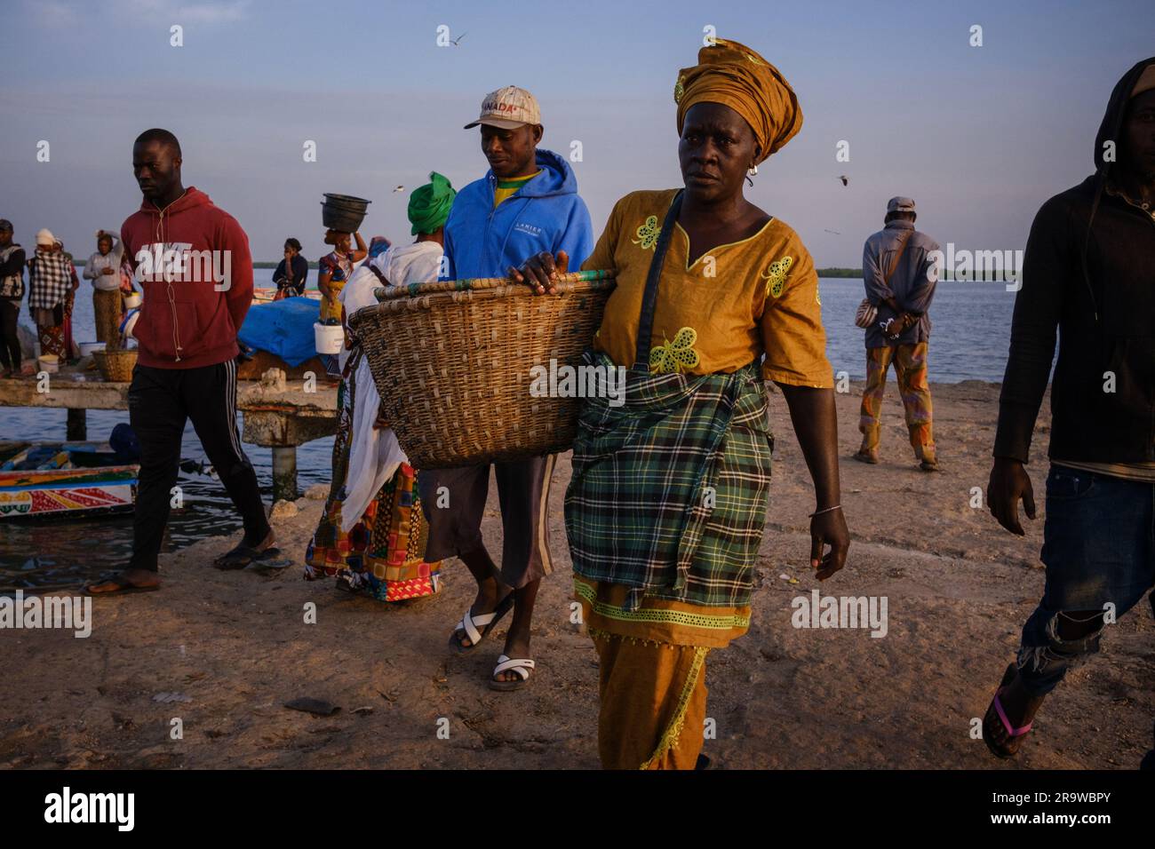La femme du marché marche avec un panier sur un marché aux poissons à Dakar, Sénégal Banque D'Images