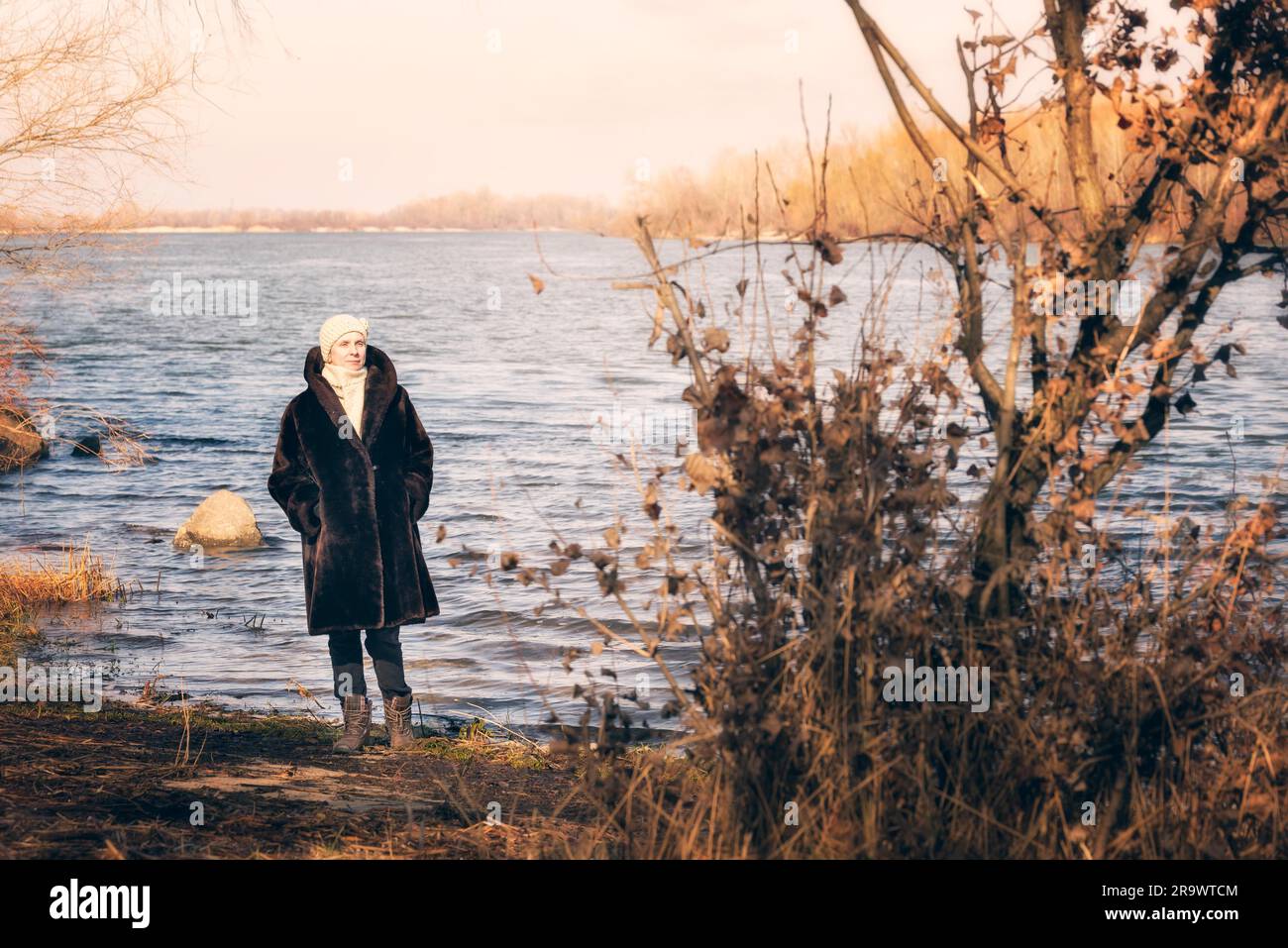 Une femme mature portant un manteau de fourrure chaude et un bonnet de reste près de le Dniepr à Kiev, Ukraine, au cours de l'hiver Banque D'Images