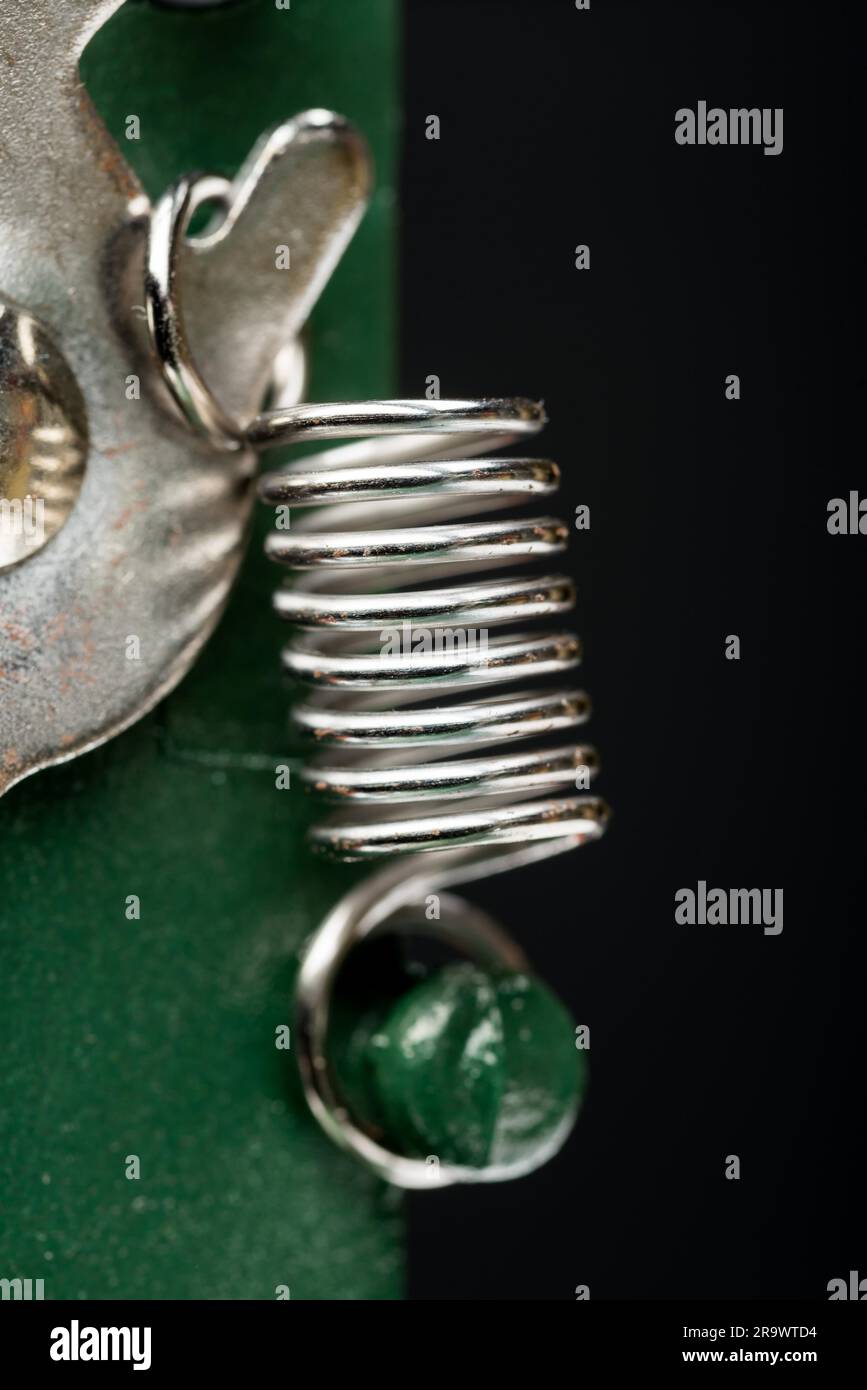 Détail d'une Macro printemps métallique sur une machine à découper, sur fond noir Banque D'Images Détail d'une Macro printemps métallique sur une machine à découper, sur fond noir Banque D'Images