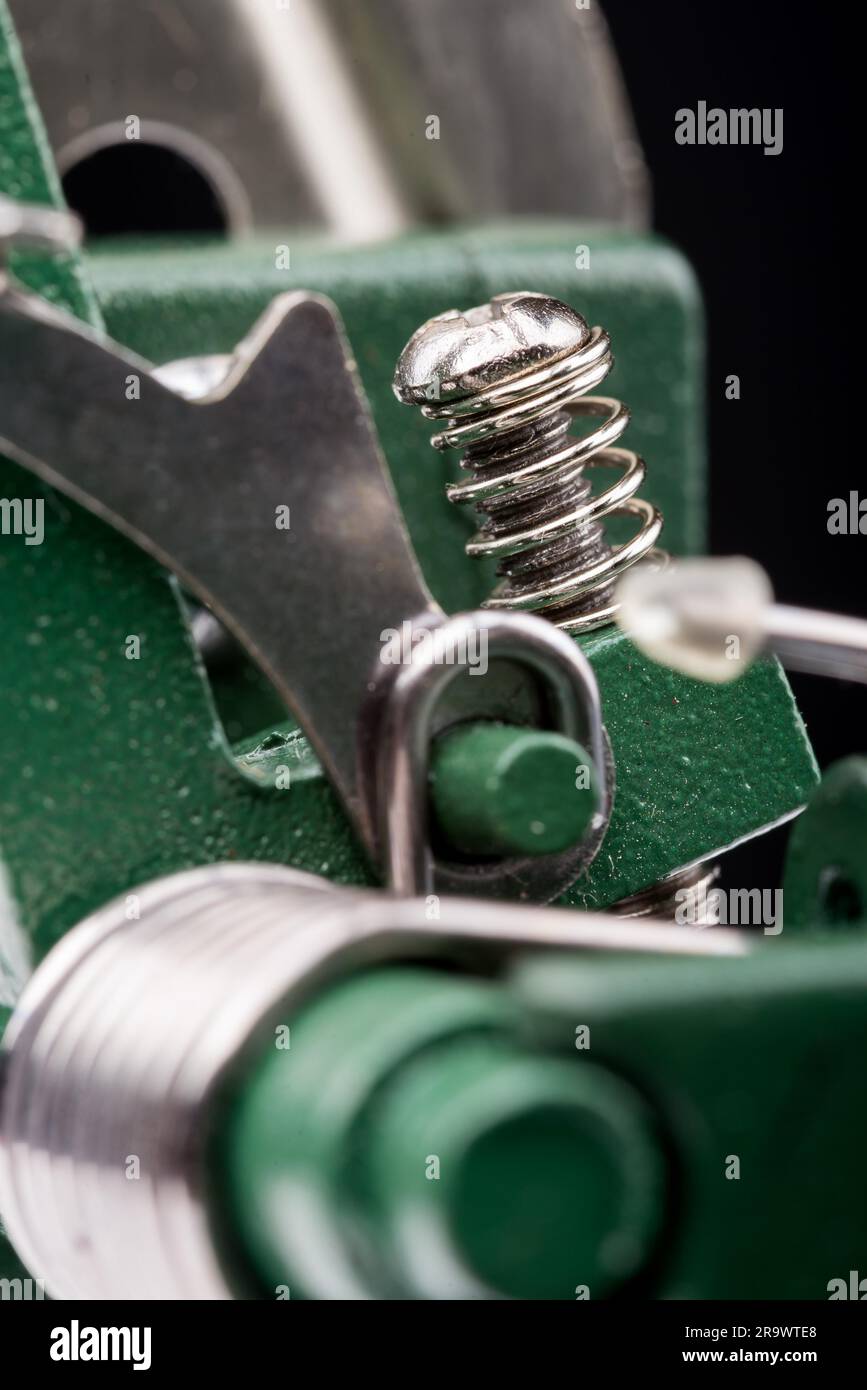 Détail d'une Macro printemps métallique sur une machine à découper, sur fond noir Banque D'Images Détail d'une Macro printemps métallique sur une machine à découper, sur fond noir Banque D'Images