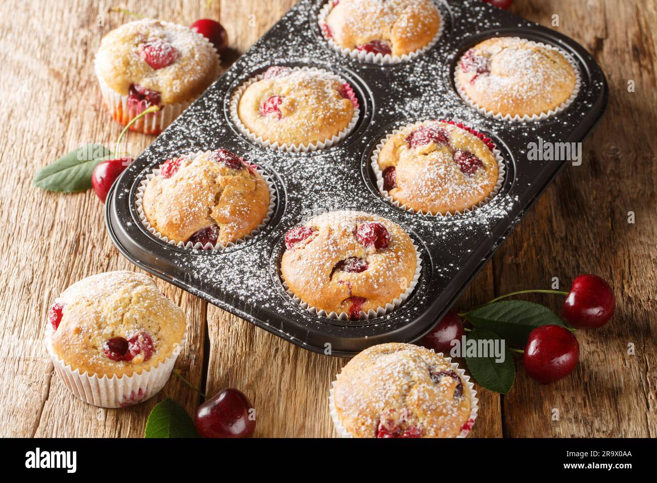 Muffins maison doux et aigre avec cerises fraîches dans un moule à muffins sur la table. Horizontale Banque D'Images