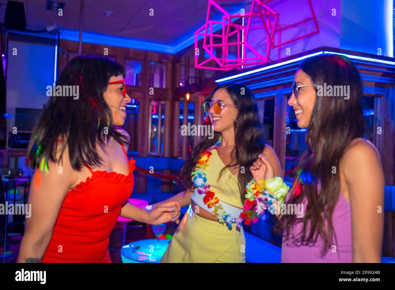 Des amies féminines dans une boîte de nuit s'amusent lors d'une soirée pendant les vacances d'été dans un pub Banque D'Images