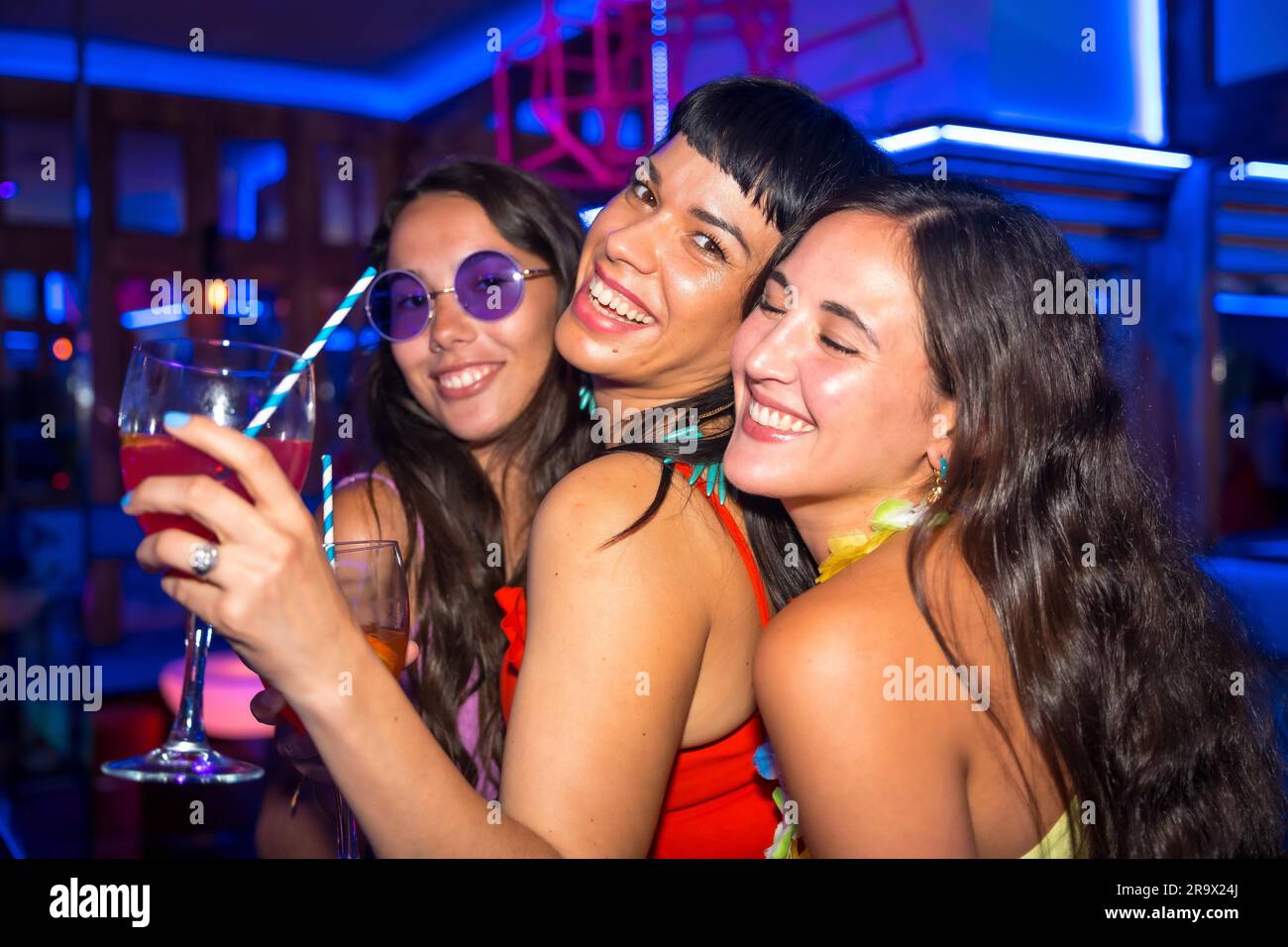 Portrait de femmes amies dans une discothèque dansant avec les lunettes lors d'une soirée d'été dans un pub Banque D'Images