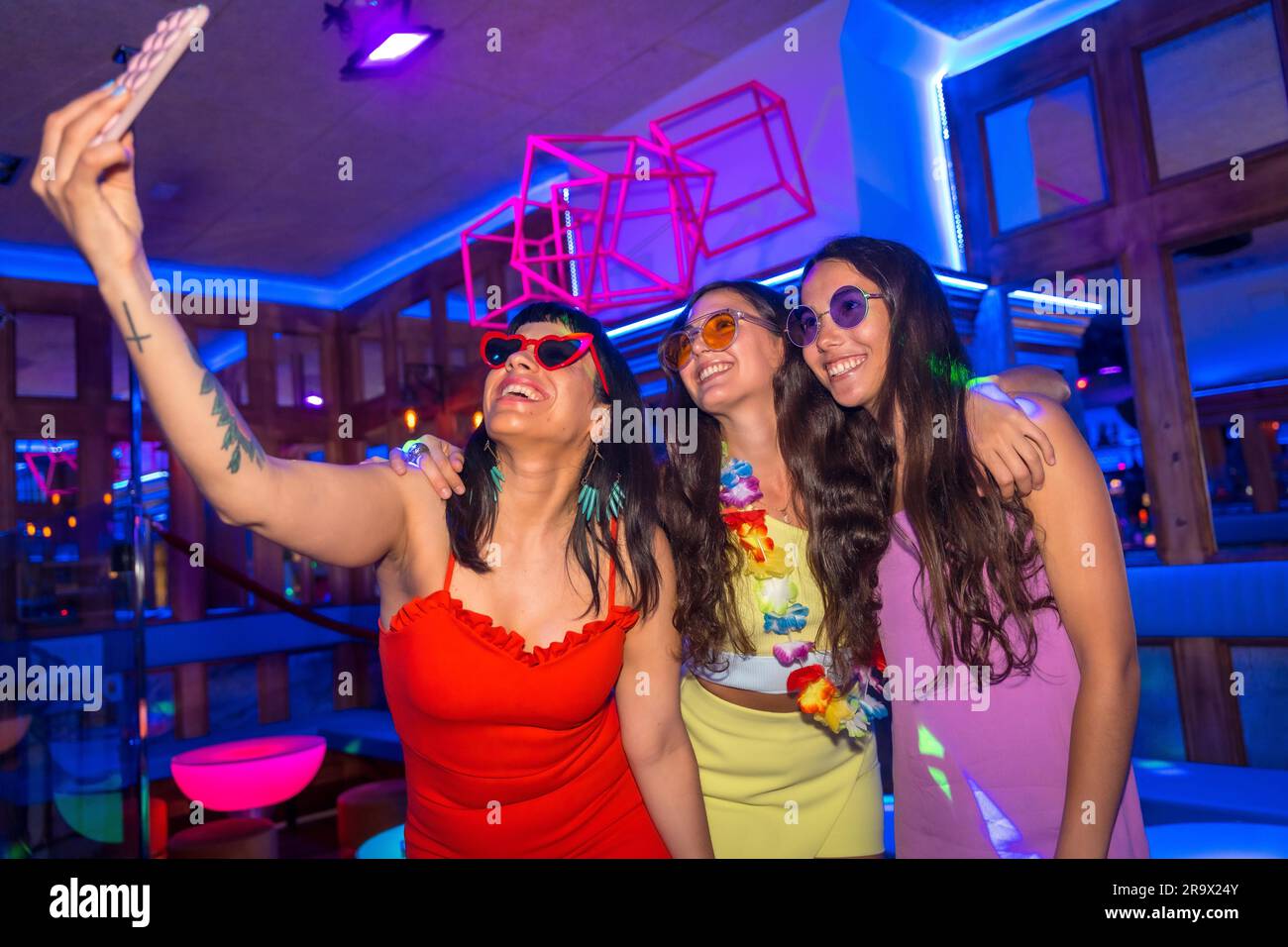 Amis à une boîte de nuit prenant un selfie lors d'une fête de nuit pendant les vacances d'été dans un pub Banque D'Images