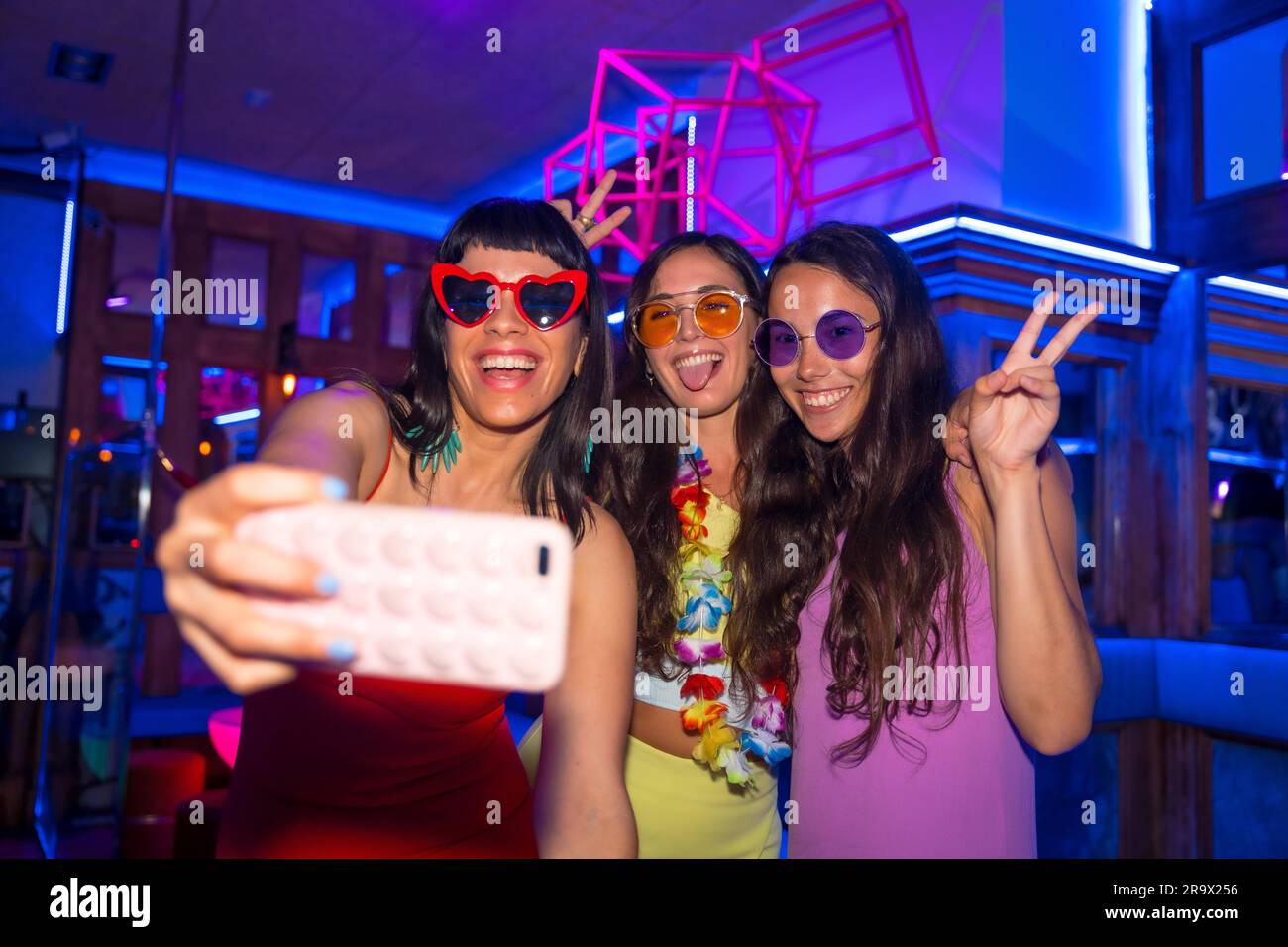 Amis à une boîte de nuit prenant un selfie lors d'une fête de nuit pendant les vacances d'été dans un pub Banque D'Images