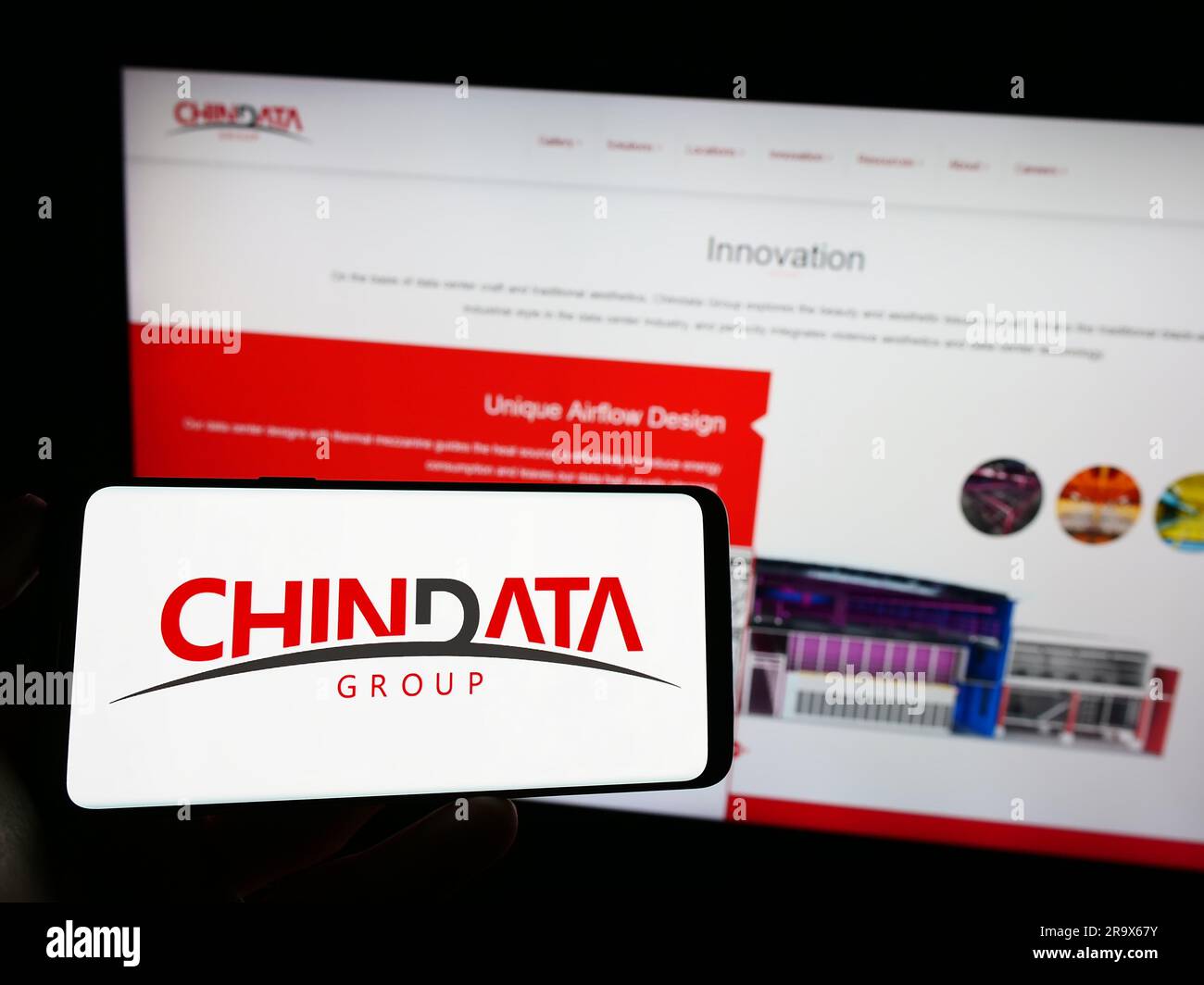 Personne tenant un téléphone portable avec le logo de la société chinoise de centre de données Chindata Group à l'écran en face de la page Web d'affaires. Mise au point sur l'affichage du téléphone. Banque D'Images