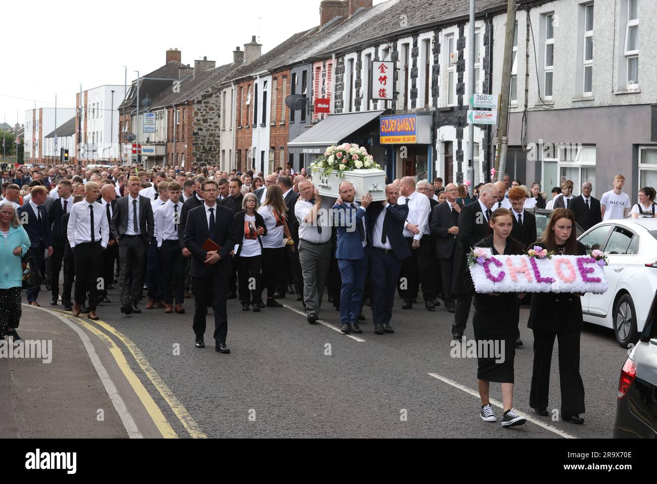 Les sœurs Kirsty (à gauche) et Nadine de Chloe Mitchell portent une couronne devant son cercueil, le long de la rue Larne, à Ballymena. Date de la photo: Jeudi 29 juin 2023. Banque D'Images