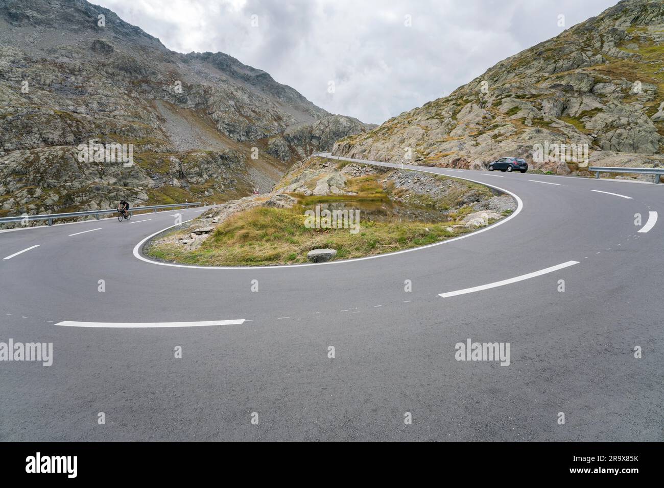 Piste cyclable et voiture sur la route de passage, San Bernardino Pass, Passo del San Bernardino, Pass dal Sogn Bernardin, région frontalière entre Canton Graubuenden Banque D'Images