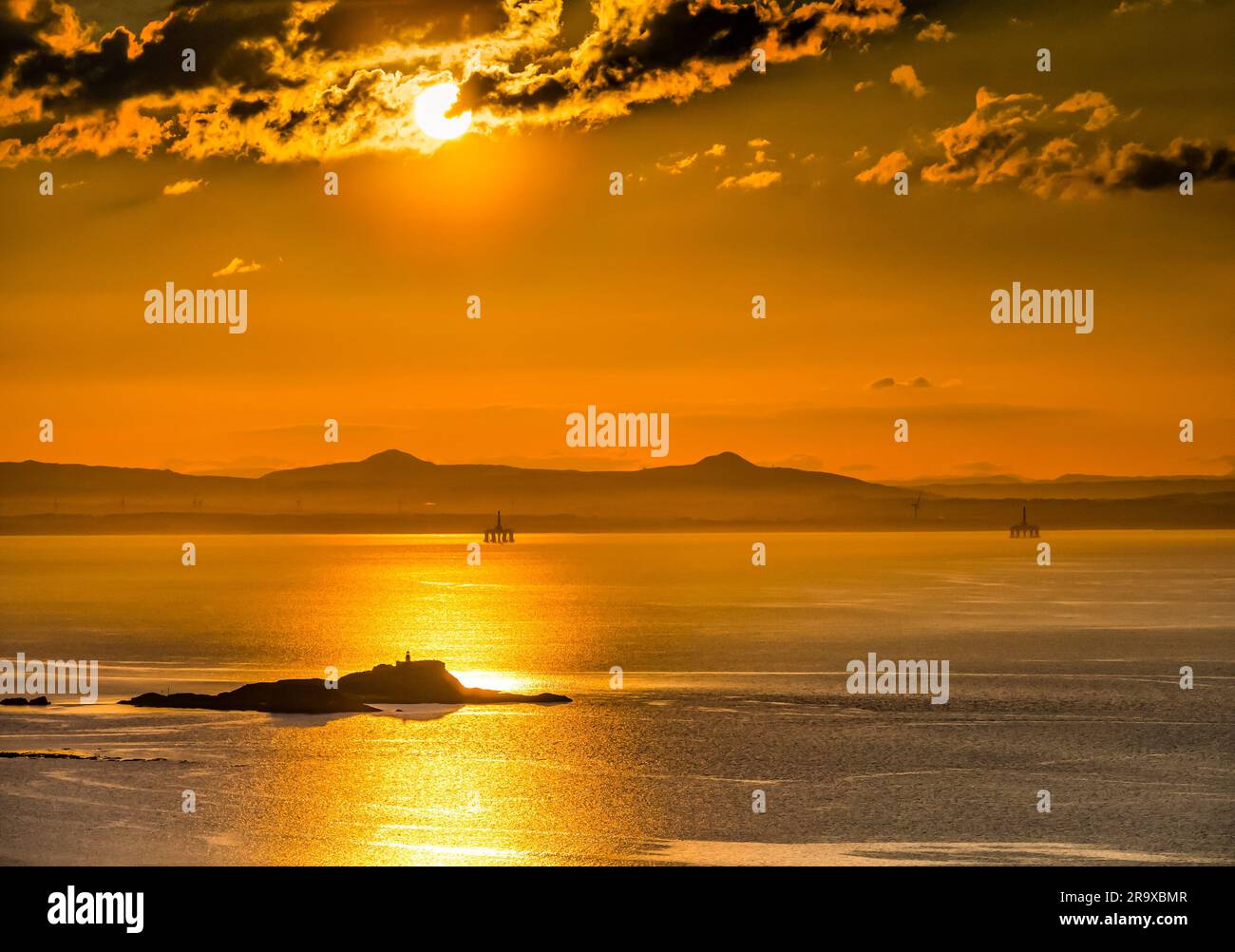 Coucher de soleil orange au coucher du soleil à travers des nuages spectaculaires sur Firth of Forth avec vue sur Fidra Island et Lomond Hills à Fife, Écosse, Royaume-Uni Banque D'Images