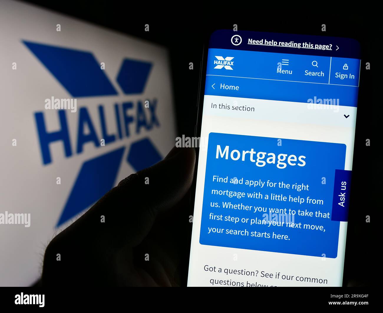 Personne tenant un téléphone cellulaire avec le site Web de la société britannique de services financiers Halifax à l'écran devant le logo. Concentrez-vous sur le centre de l'écran du téléphone. Banque D'Images