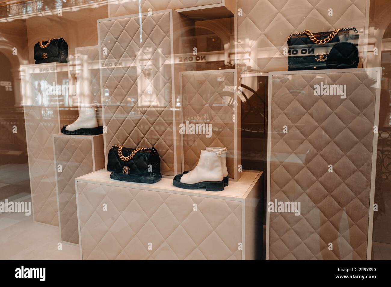 Meuble beige neutre Chanel avec sac à main noir et chaussures blanches dans la fenêtre d'un magasin de luxe Chanel est une marque de haute couture fondée par Coco Chanel in Banque D'Images