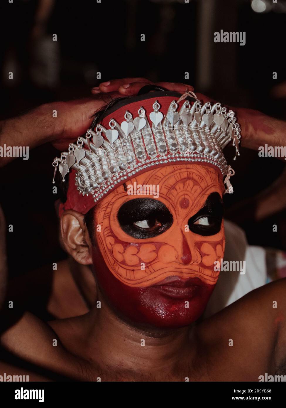 un portrait en gros plan d'un artiste avec maquillage de peinture de visage qui exécute theyyam, une danse traditionnelle et une forme d'art qui célèbre et vénère la culture hindoue Banque D'Images