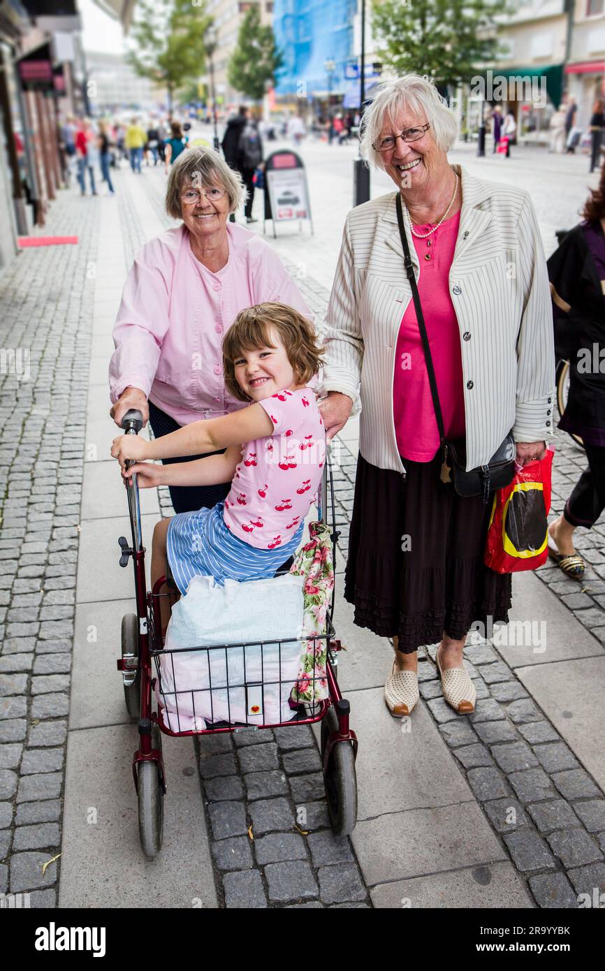 Des femmes âgées avec une petite fille assise dans un panier Banque D'Images