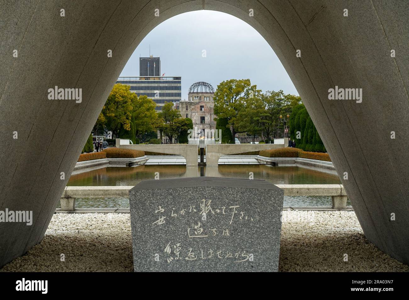 Le cénotaphe commémoratif des victimes d'Hiroshima au Parc commémoratif de la paix d'Hiroshima, au Japon, avec la ruine du dôme de la bombe A. Banque D'Images