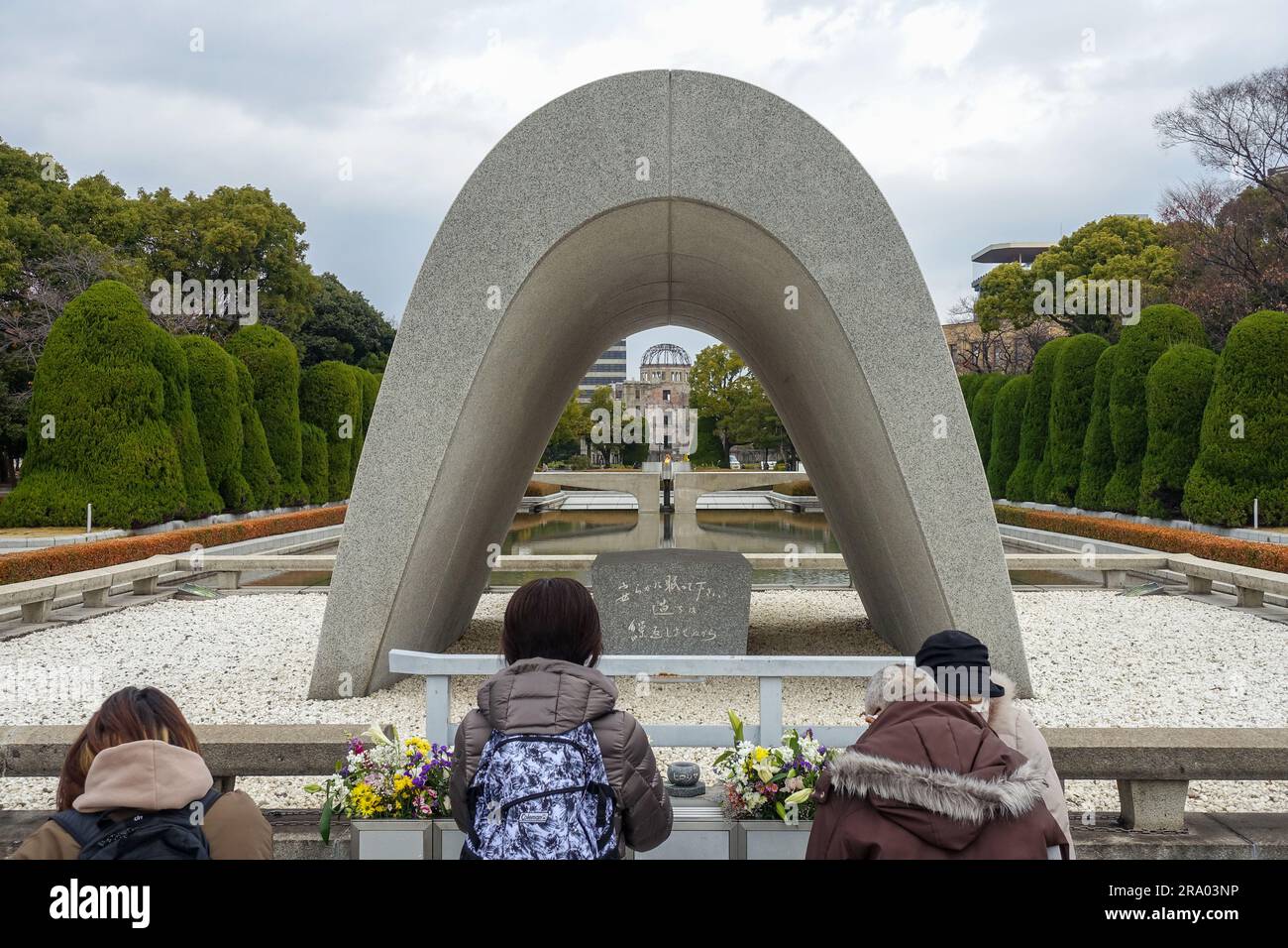 Trois femmes priant face au cénotaphe commémoratif des victimes d'Hiroshima au Parc commémoratif de la paix d'Hiroshima, au Japon Banque D'Images