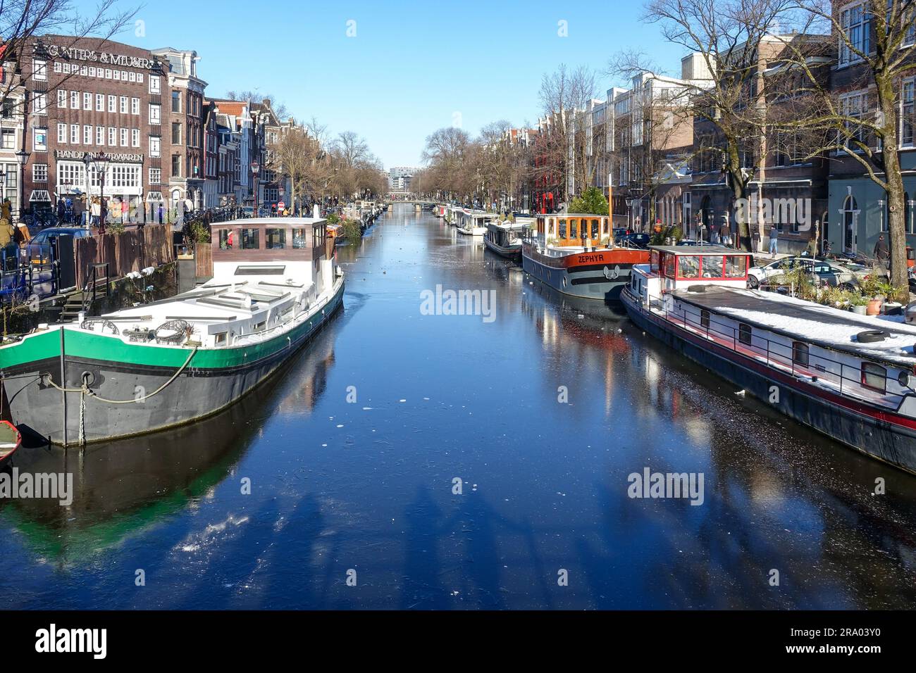 Bateaux sur les canaux gelés d'Amsterdam pendant une froide journée d'hiver de février 2021 Banque D'Images
