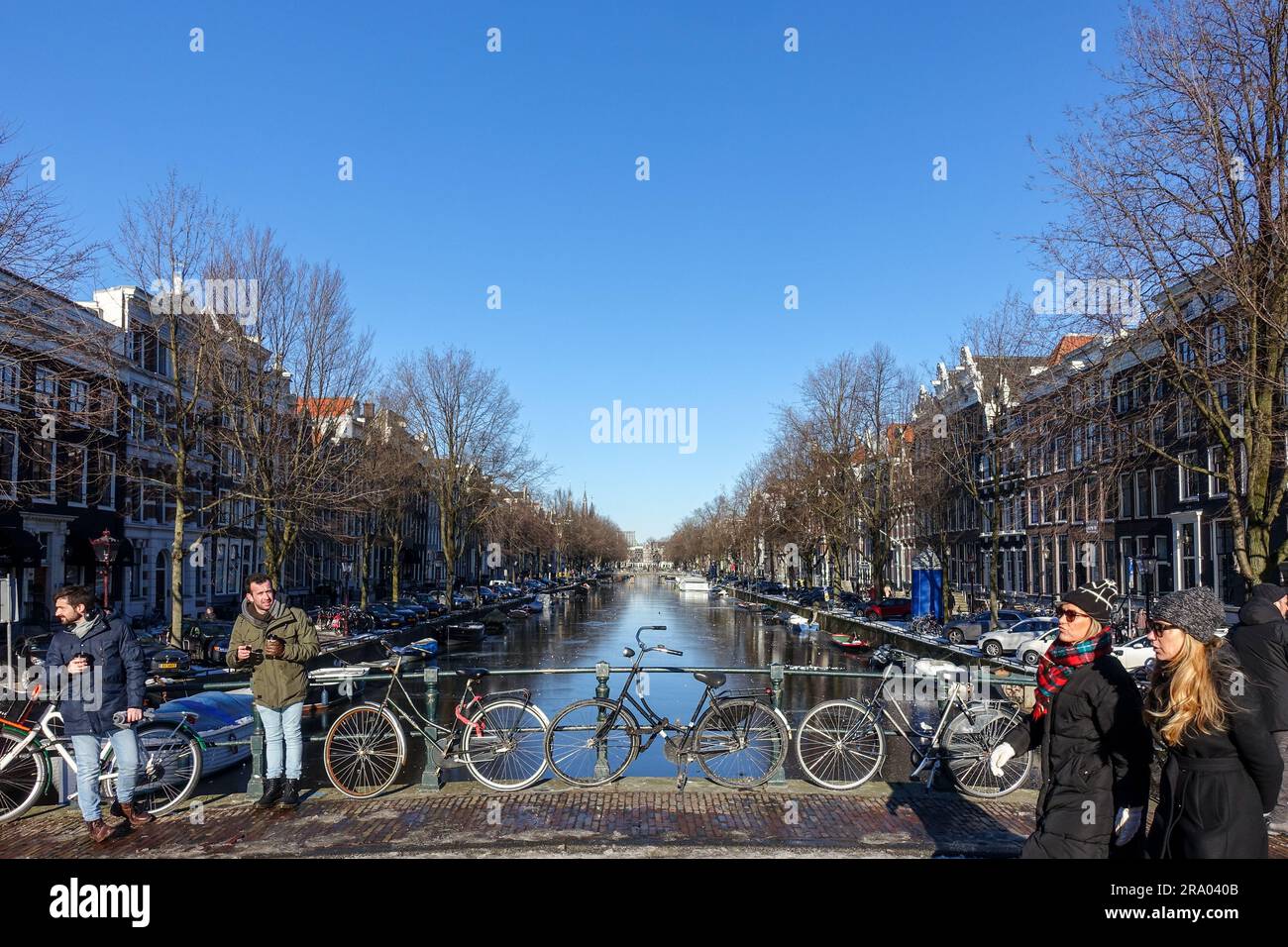 Canaux gelés par un ciel bleu ensoleillé jour d'hiver à Amsterdam, pays-Bas Banque D'Images