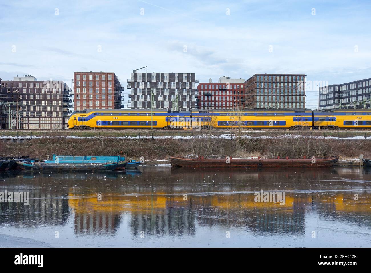 Train NS (pays-Bas) réfléchissant sur des canaux gelés à Amsterdam Banque D'Images