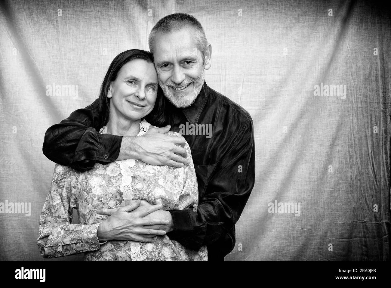 Heureux homme et femme mûrs souriant pour la Saint-Valentin ou anniversaire et s'embrassant l'un l'autre. Photo en noir et blanc Banque D'Images